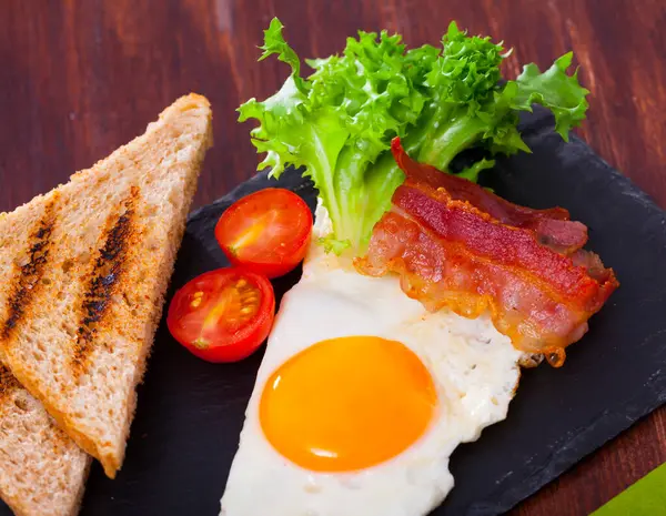 Picture Fried Eggs Bacon Toasted Bread Tomatoes Lettuce Plate Table — Stock Photo, Image