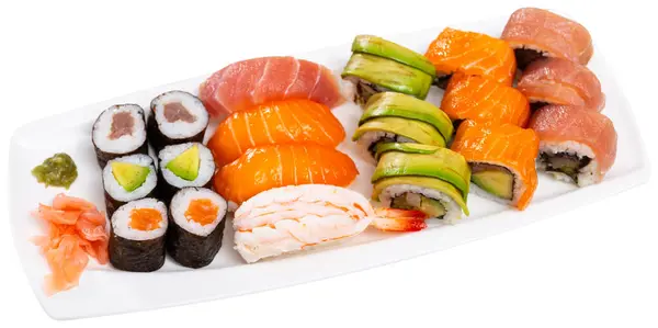 Hearty lunch has been prepared - uramaki sushi set and nigiri with avocado, cucumber, soft cheese and salmon on white plate. Isolated over white background