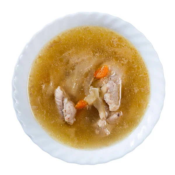 Freshly prepared hearty lunch awaits on table - fragrant cabbage soup with potato, carrot and pork ribs. Isolated over white background