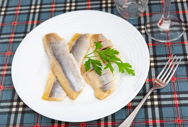 Sliced raw marinated fish herring served on platter