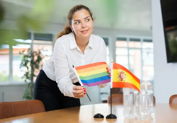 비즈니스 여자는 사무실에서 테이블에 스페인어와 Lgbt 깃발을 — 스톡 사진