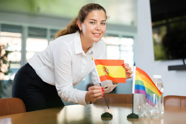 Young Woman Business Clothes Puts Small Spanish Lgbt Flags Table — Stock Photo, Image