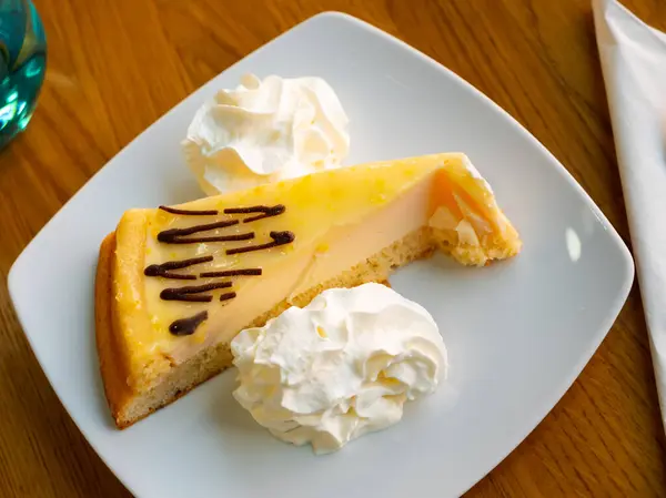 Piece of sweet lemon pie with cream served for dessert