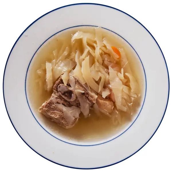 Freshly prepared hearty lunch - fragrant cabbage soup with potato, carrot and pork rib. Dish is complemented with plate of bacon and bread. Isolated over white background