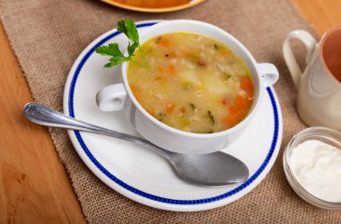 Traditional Russian thick sour soup rassolnik served with a piece of boiled beef clipart