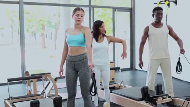 Spanyol Kadın Pilates Eğitmeni Genç Kakuasyalı Kadın Reformcular Üzerinde Egzersiz — Stok video