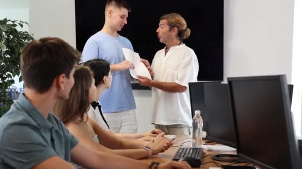 Wśród Studentów Kursów Komputerowych Człowiek Nauczyciel Przyznaje Patent Dyplomowy Przedstawia — Wideo stockowe