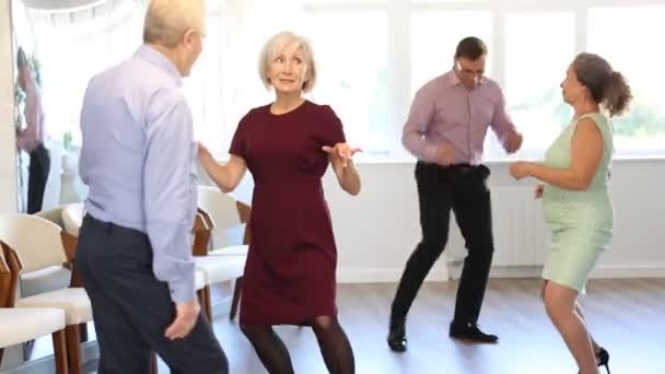 スタジオでツイストを踊る成人男性と高齢女性のカップル — ストック動画