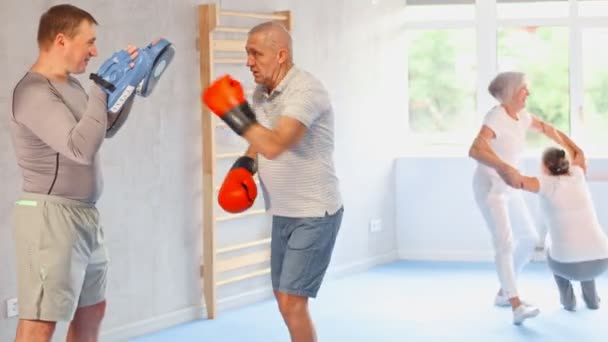 ボクシングのトレーナーが抱える焦点を当てた高齢男性 高品質の4K映像 — ストック動画