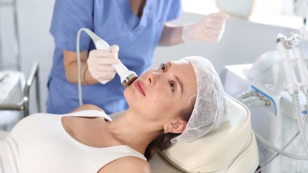 Kosmetolog Perempuan Muda Melakukan Prosedur Ultrasonografi Perangkat Keras Wajah Untuk — Stok Video