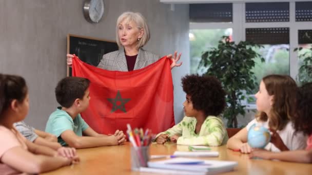 Dojrzała Nauczycielka Gimnazjum Prowadząca Lekcję Klasie Trzymająca Flagę Narodową Marroko — Wideo stockowe