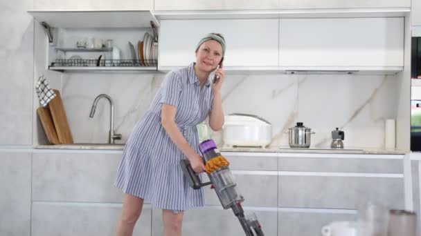 Hausfrau Putzt Den Raum Gleichzeitig Staubsaugen Und Auf Dem Smartphone — Stockvideo