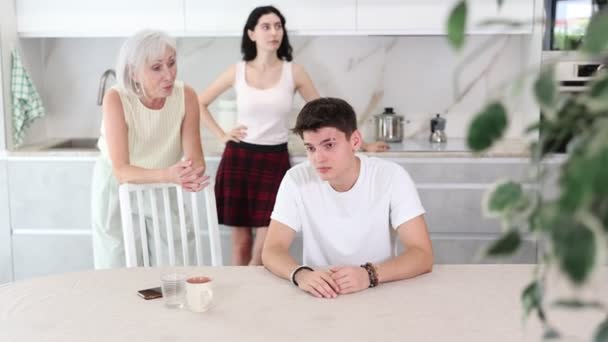 高齢の女性と少女は男に誓った 母と姉は大学で失敗した研究のために若者を叱った 複雑な世代間関係 — ストック動画