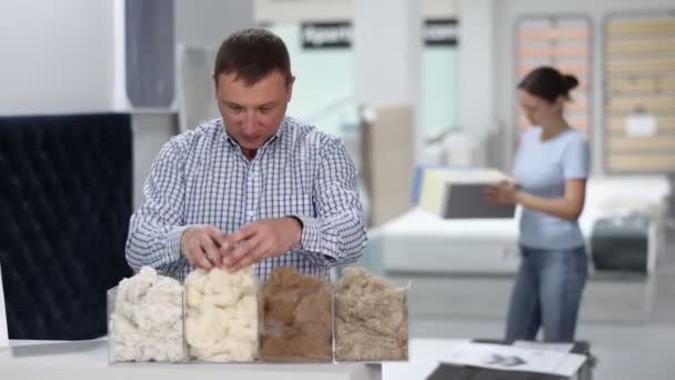 Man Examines Samples Mattress Fillers Furniture Store High Quality Footage — Stock Video