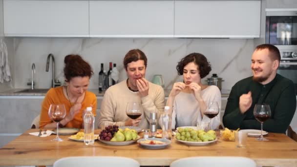 自宅でテーブルでホリデー飲酒とチャットを祝う幸せなグループ — ストック動画
