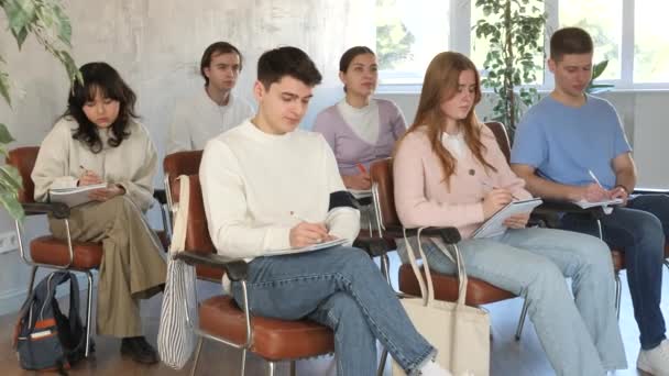 Estudiantes Secundaria Escuchando Lección Con Interés Tomando Notas Sentados Sillas — Vídeos de Stock