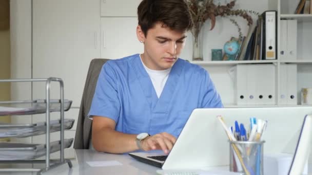 Άντρας Γιατρός Που Εργάζεται Κλινική Δακτυλογραφεί Αρχείο Ραντεβού Θεραπείας Ασθενών — Αρχείο Βίντεο