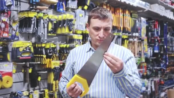 Мужчина Выбирает Ножовку Хозяйственном Магазине Высококачественные Fullhd Кадры — стоковое видео