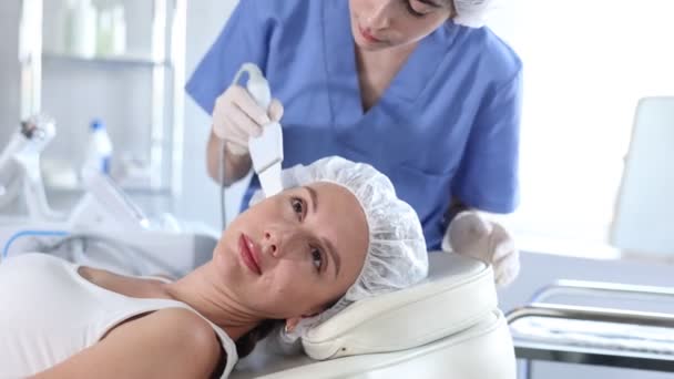麻酔薬クリニックで顔のケアのためのハードウェア化粧品治療を受けている若い女性は 皮膚を浄化し 柔らかくし 余分なケラチンを除去するために超音波シャベルを使用して コラーゲンの生産を後押しします — ストック動画