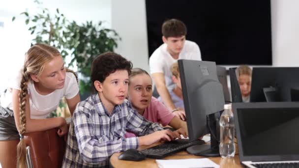 Itコース中のトレーナーと一緒にコンピュータのモニターを監視している不思議な未成年少年少女 — ストック動画