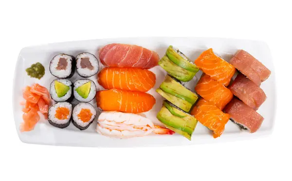 Sushi set con maki with uramaki rolls and salmon nigiri is served in white narrow rectangular plate. Traditional Japanese Asian cuisine, gastronomy tourism. Isolated over white background