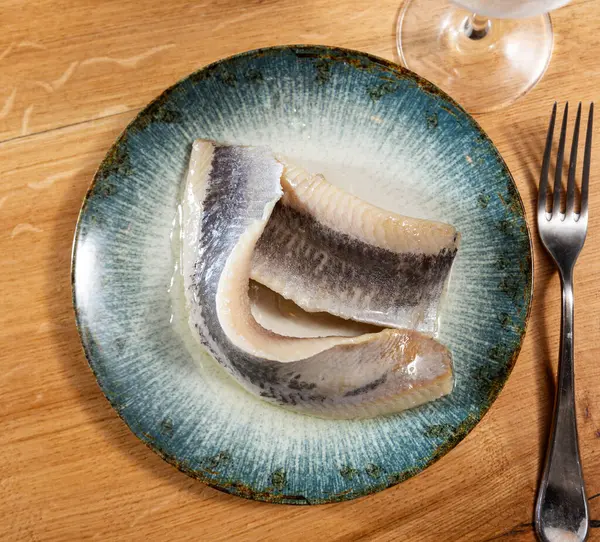 Sliced raw marinated fish herring served on platter