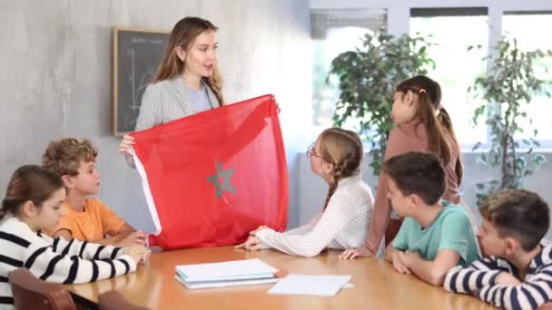モロッコの学校の子供のための旗を示す若い女性の教師は聴覚の地理学のレッスン中に目立つ — ストック動画