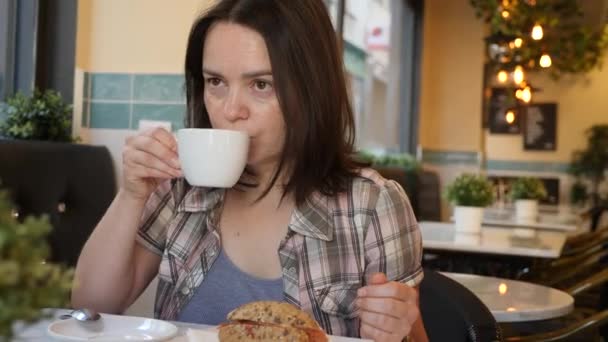 Γυναίκα Τρώει Πρωινό Στο Καφέ Σάντουιτς Και Καφέ Υψηλής Ποιότητας — Αρχείο Βίντεο