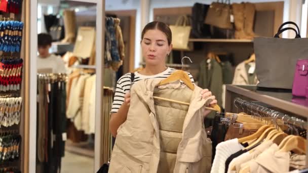Inspectie Van Winkels Assortiment Meisje Kiest Vest Hangers Nauwkeurig Onderzoekt — Stockvideo
