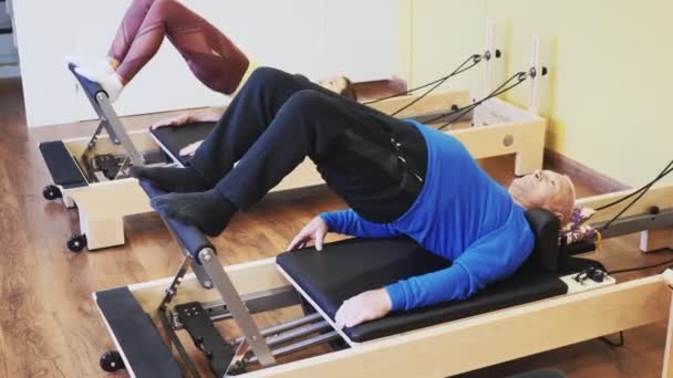 Mature Man Practicing Pilates System Reformer Supervised Gym High Quality — Video Stock