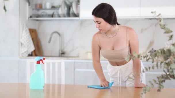 Задоволена Молода Жінка Очищає Стіл Кухні Допомогою Пиломатеріалу Розпилювача — стокове відео