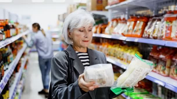 Interested Positive Senior Lady Reading Label Packages Asian Noodles While — Vídeo de stock