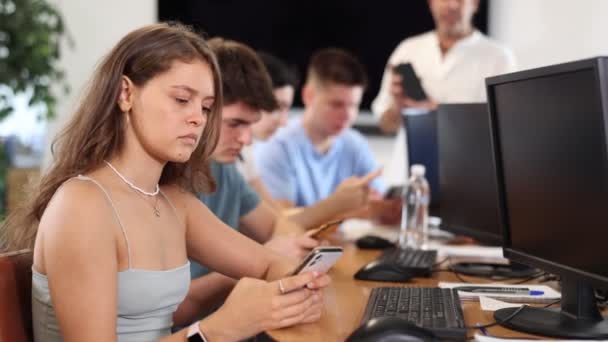 Sınıfta Bilgisayar Okulunda Genç Kız Öğrenci Cep Telefonuyla Oturur Hayranlıkla — Stok video