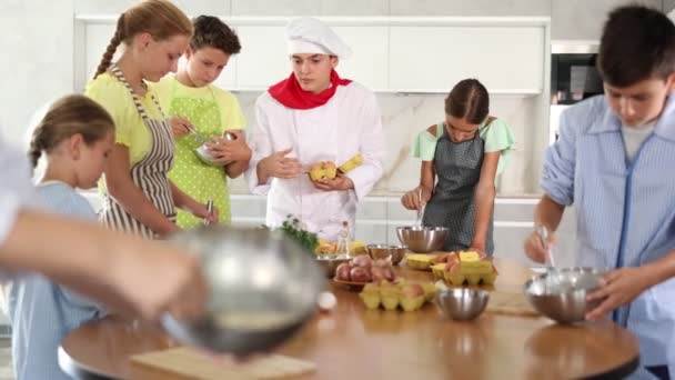 Chico Joven Cocinero Uniforme Enseña Grupo Niños Cómo Cocinar Plato — Vídeo de stock
