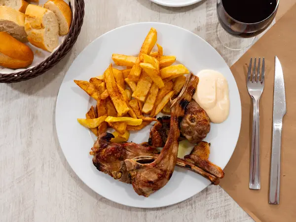 Delicious browned baked lamb ribs served with crispy french fries and creamy aioli sauce