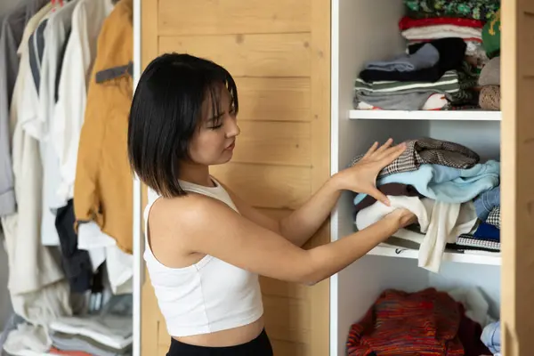 Ευτυχισμένη Νεαρή Ασιάτισσα Που Βάζει Κάποια Ρούχα Στην Ντουλάπα Στα — Φωτογραφία Αρχείου