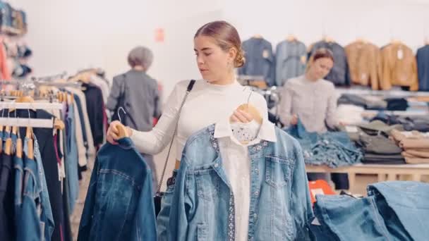Mladá Žena Kupující Vybere Džínovou Bundu Obchodě Oblečením — Stock video