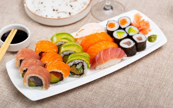 寿司设置与乌拉麦卷和鲑鱼黑鬼在白色狭窄矩形盘 日本传统亚洲菜 美食旅游 — 图库照片