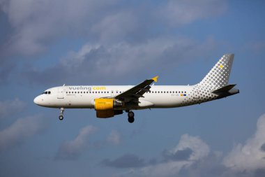 BARCELONA, SPAIN - JANUARY 23, 2020: Vueling airbus A320 with EC-JZI registration flying on cloudy day, approaching landing in Barcelona-El Prat Airport clipart