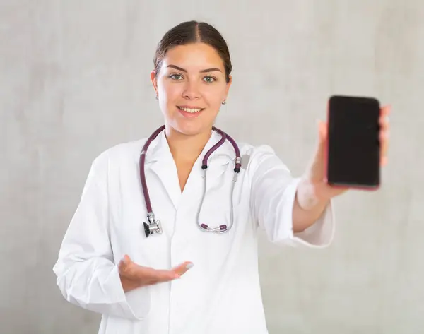 Female Doctor White Coat Extending Hand Phone Showing Screen Selective — Stock Photo, Image