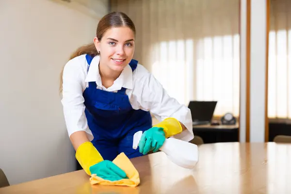Młoda Kobieta Biurku Sprzątania Czyści Kurz Szmatą Detergentem Spryskiwaczu Ręcznym — Zdjęcie stockowe