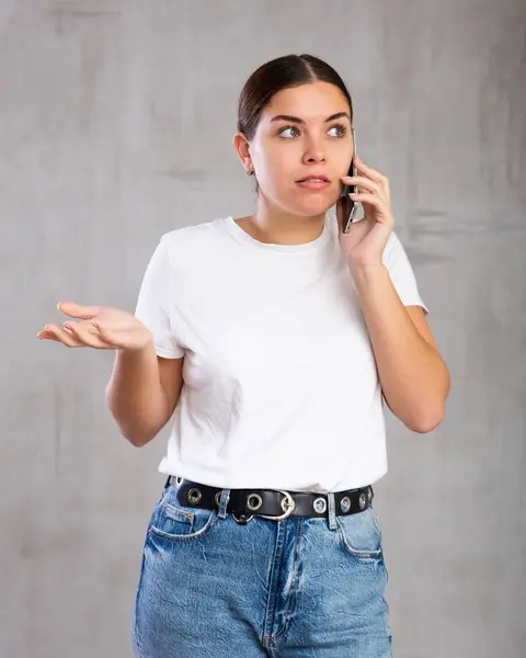 Photo Astonished Young Woman Speaking Mobile Phone Concern Gray Shadeless — Stock Photo, Image