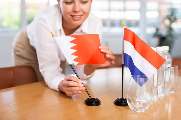 Young Woman Business Clothes Puts Flags Bahrain Netherlands Negotiating Table — Stock Photo, Image