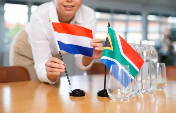 네덜란드의 깃발이있는 테이블에 프리카 공화국의 깃발은 회의실에서 긍정적 여성에 — 스톡 사진