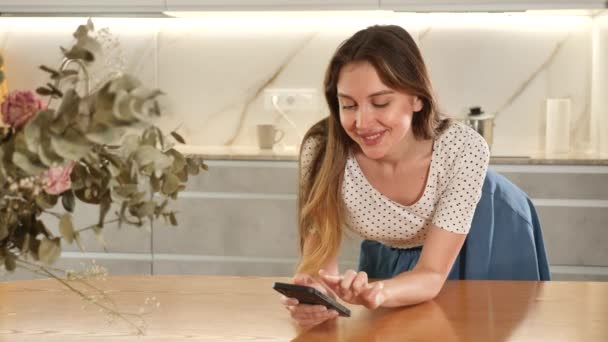 Joyous Mulher Meia Idade Inclinada Mesa Segurando Seu Telefone Celular — Vídeo de Stock
