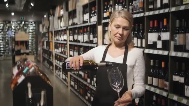 以成熟女性葡萄酒生产者为研究对象 以酒瓶货架为背景 对葡萄酒的质量进行检测 优质Fullhd影片 — 图库视频影像