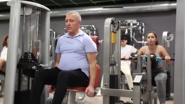Yaşlı Adam Spor Salonunda Kol Kaslarını Simülatörde Çalıştırıyor Yüksek Kalite — Stok video