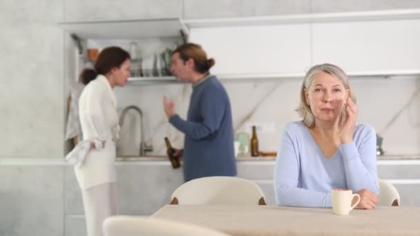 Sfrustrowana Starsza Kobieta Siedzi Kuchni Podczas Kłótni Między Synem Jego — Wideo stockowe