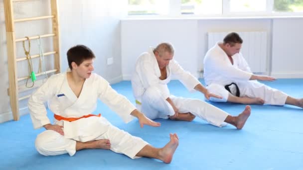 Focused Sporty Teenage Guy White Kimono Doing Stretching Exercises Relieve — Stock Video