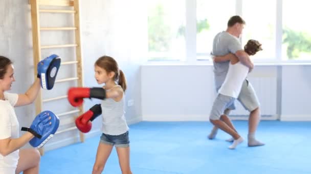 戴拳击手套的小女孩在体育馆里从她妈妈的拳击手套里学习拳击 高质量的4K镜头 — 图库视频影像